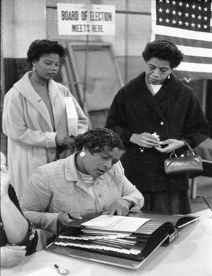 Three African American Women at a Polling Place, One Looking at a Book of Registered Voters on November 5 in New York City or Newark, New Jersey