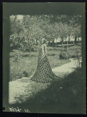 Emilie Floge wearing a reform dress from the Schwestern Floge and jewelry from the Wiener Werkstatte, standing in the garden of the Villa Oleander on the Attersee